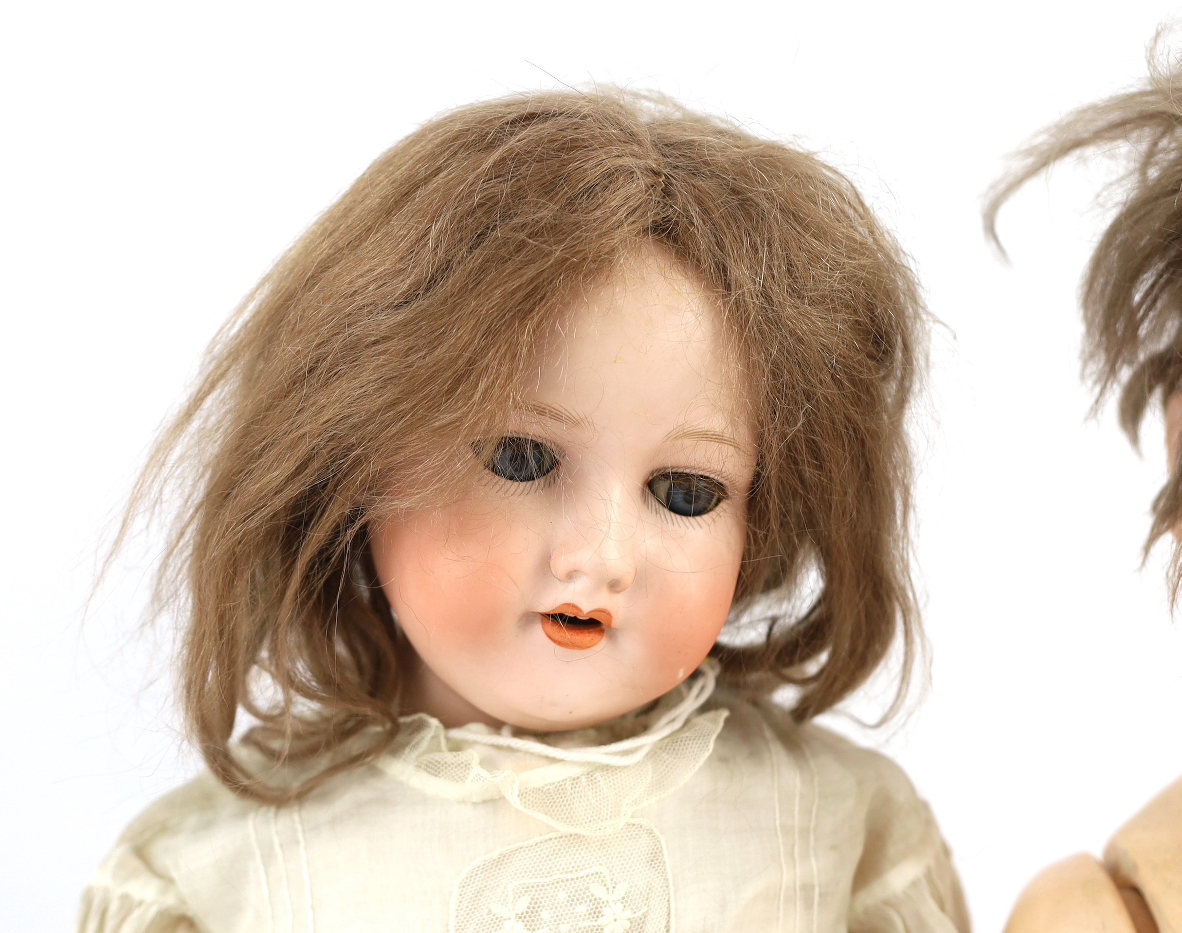 An Armand Marseille bisque doll, German, circa 1912, 24in. and 21in. resp.